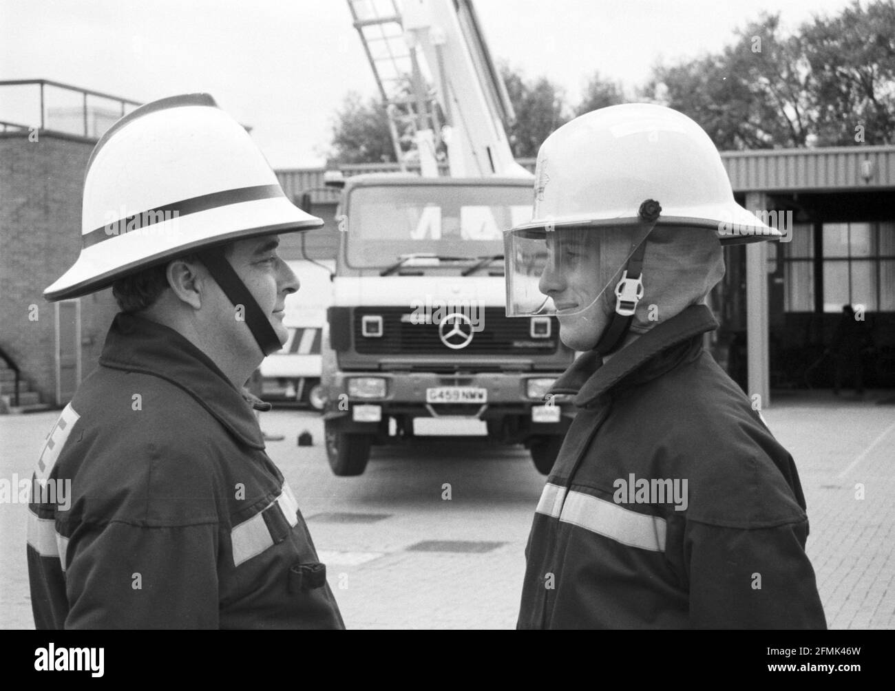 Nouveau v ancien style de casque de pompier. Le nouveau casque, à droite, est dévoilé à la caserne de pompiers de Salisbury, dans le Wiltshire, en 1990. Banque D'Images