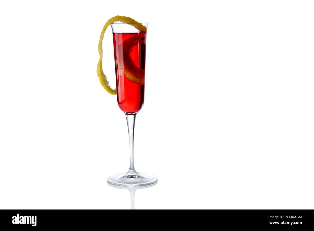Cocktail rouge avec zeste de citron en trompette isolée sur blanc, espace copie Banque D'Images