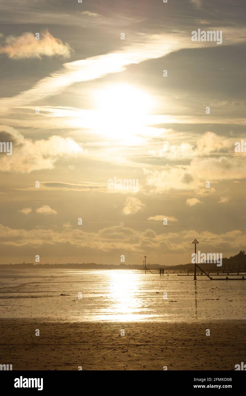 Heure d'or sur la côte sud anglaise avec le soleil bas se reflétant dans l'eau de surface. Banque D'Images