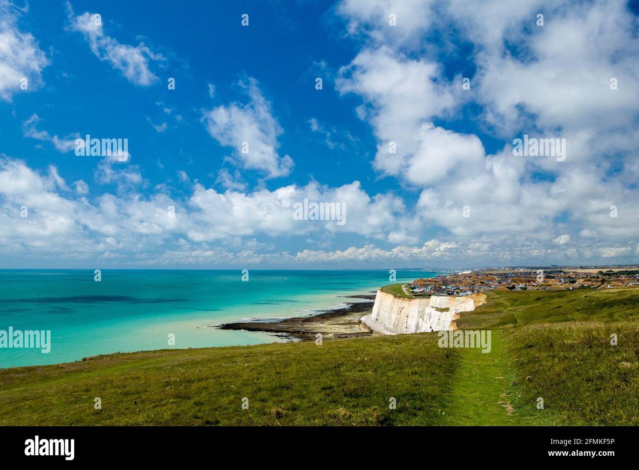 La vue vers Peacehaven, Sussex Royaume-Uni depuis les hauteurs de Newhaven à marée basse lors d'une journée d'été ensoleillée avec des cumulus dans le ciel. Banque D'Images