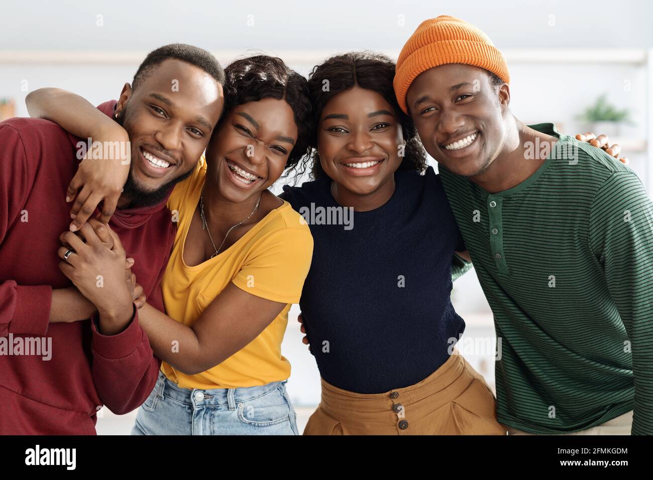 Portrait de joyeux couples afro-américains millénaires, intérieur de salon, les mecs noirs mignons et les dames dans une ambiance décontractée ayant double date à la maison, huggi Banque D'Images