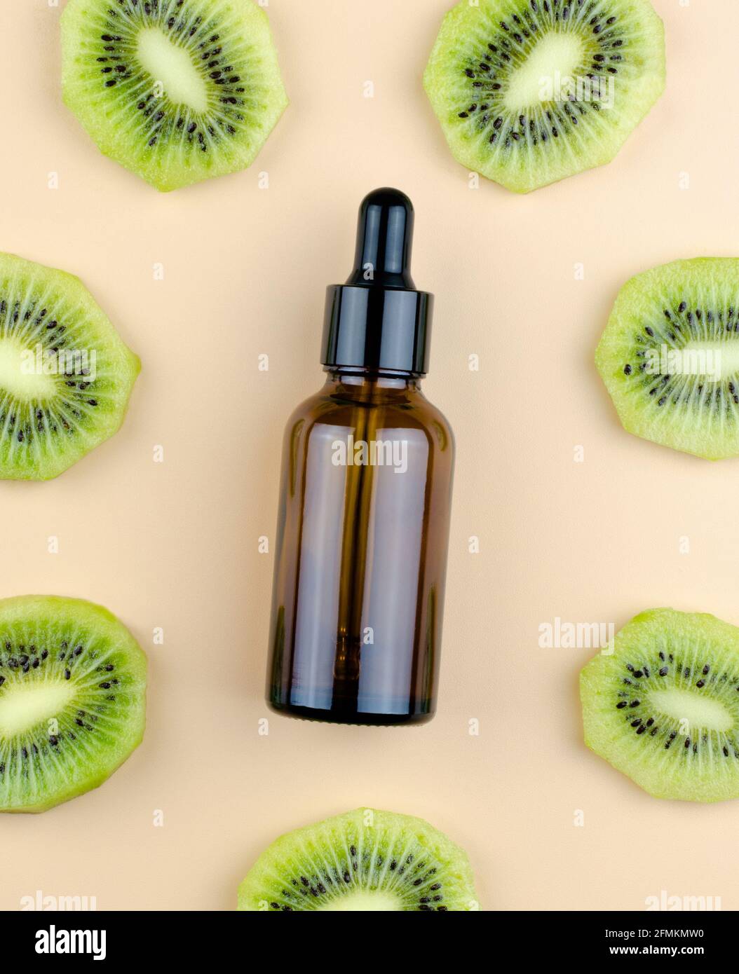 Huiles à l'extrait de kiwi. Produit cosmétique aromatique pour les soins de la peau et des cheveux. Sérum dans un flacon en verre avec une pipette. Emballage d'un produit cosmétique. Banque D'Images