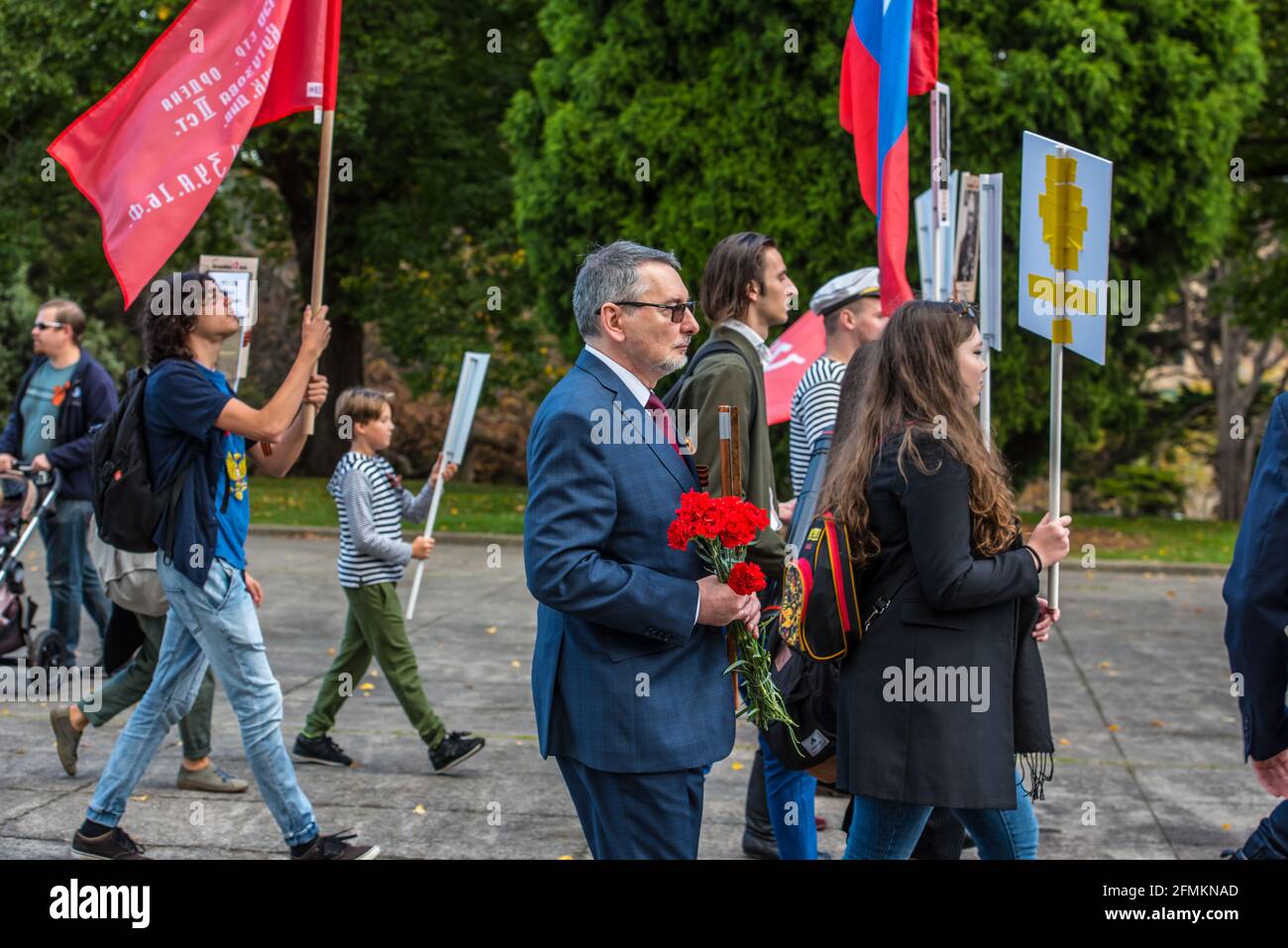 L'Ambassadeur Alexey Pavlovsky organise des œillets rouges lors de la marche du Régiment Immortal à Melbourne. « Immortal Regiment », une partie de la célébration du jour de la victoire le 9 mai au mémorial du Temple du souvenir à Melbourne. La marche du Régiment d'Immortal a été suivie par l'ambassadeur de Russie en Australie et un premier secrétaire de l'ambassade de Russie et fait partie d'une célébration mondiale de la victoire. Des personnes avec des drapeaux, des bannières et surtout des photos des membres de leur famille qui se sont battus pendant la Seconde Guerre mondiale ont défilé dans les rues de Melbourne. La marche commémore tous les soldats et anciens combattants morts Banque D'Images