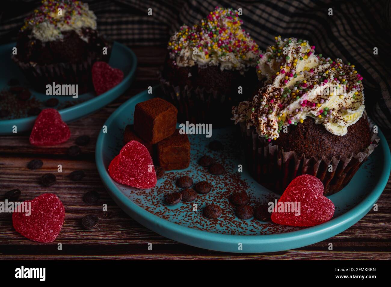 Délicieux muffin au chocolat avec topin de crème blanche aux saupoudrées colorées, truffes et bonbons en forme de coeur pour la fête de la Saint Valentin pour l'amour Banque D'Images