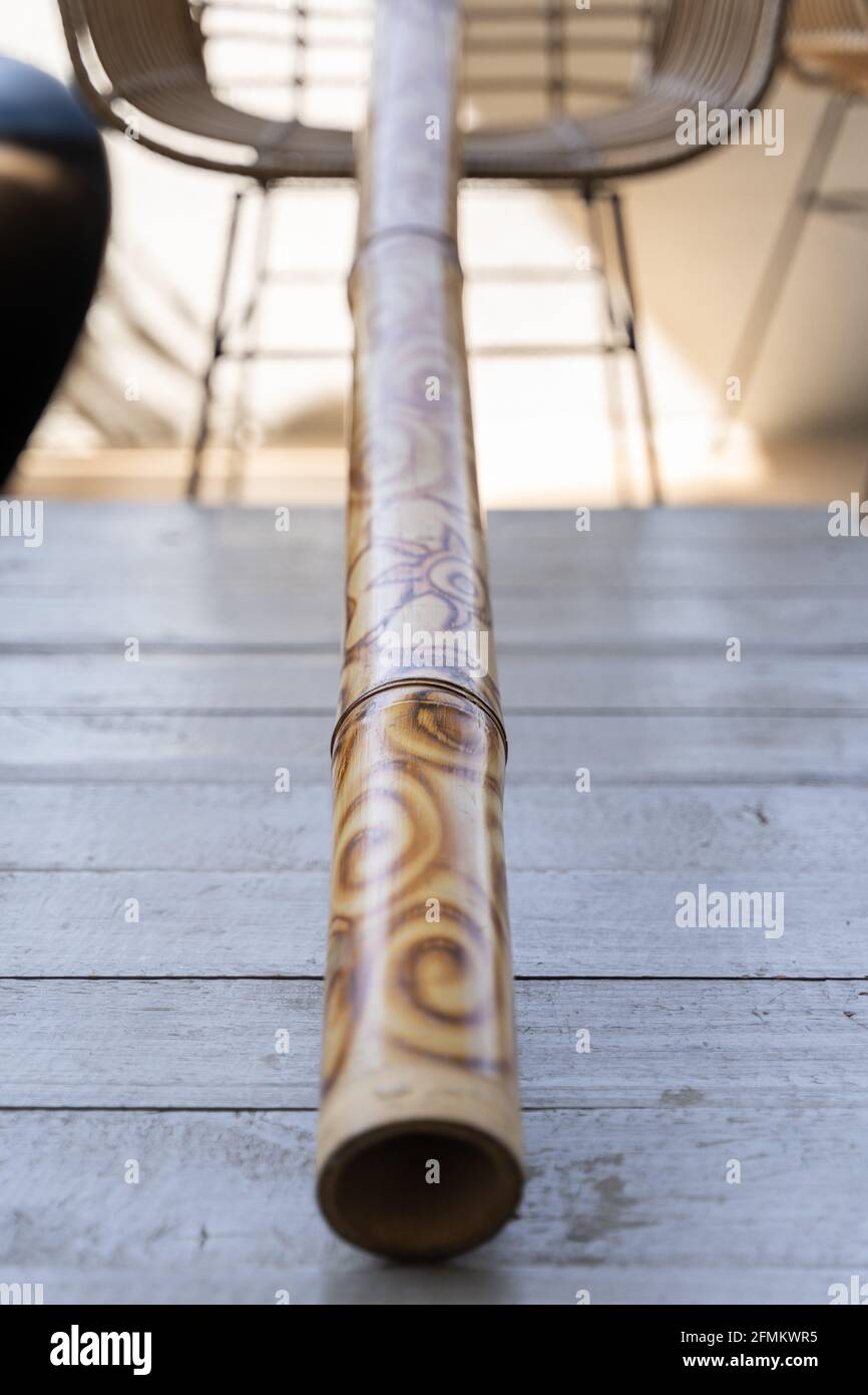 Didgeridoo décoré de motifs abstraits sur une table grise. Instrument de musique australien traditionnel en bois Banque D'Images