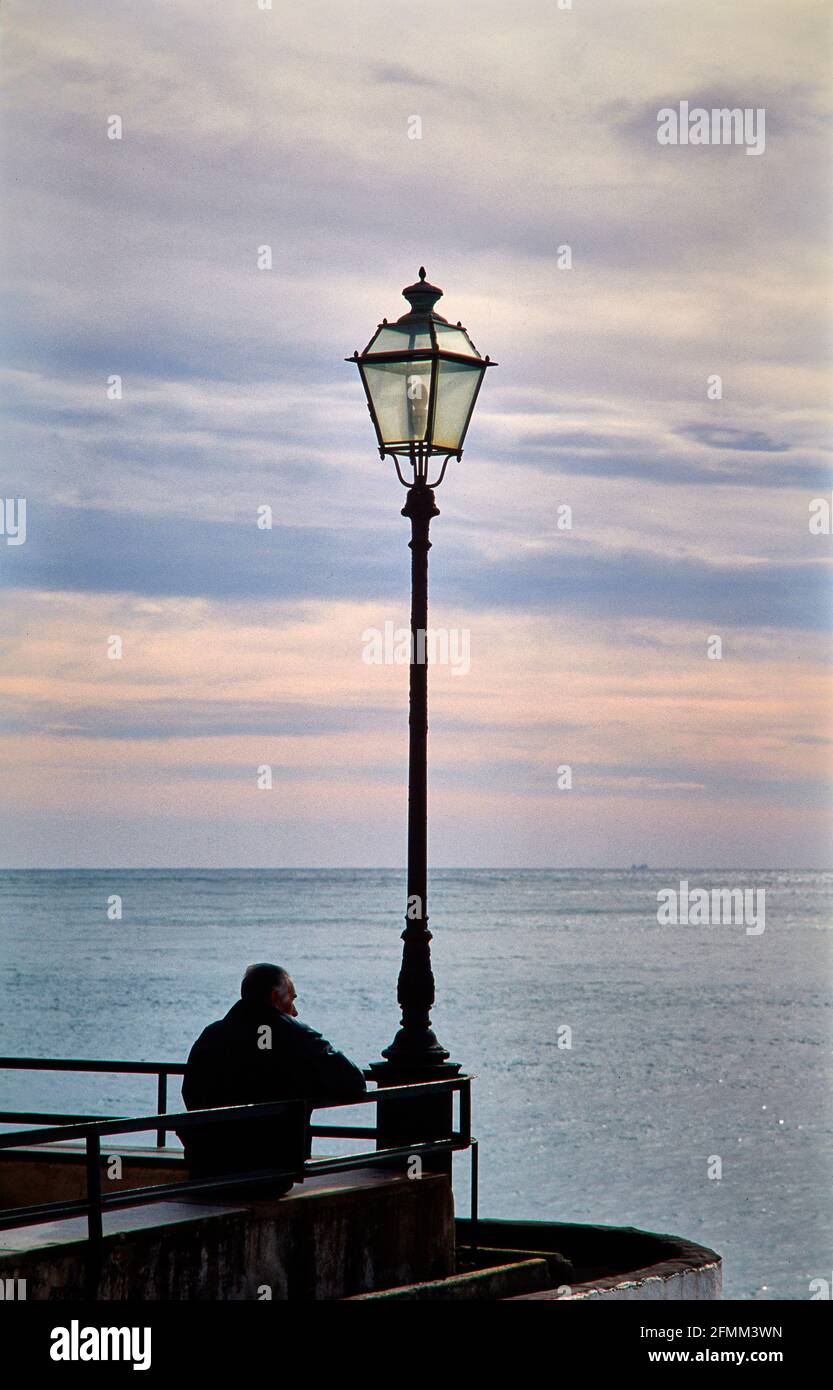 Perdu en pensée, un homme regarde la mer depuis la promenade de Camogli sur le Golfo Paradiso sur la Riviera di Levante. 06.10.2003 - Christoph Keller Banque D'Images