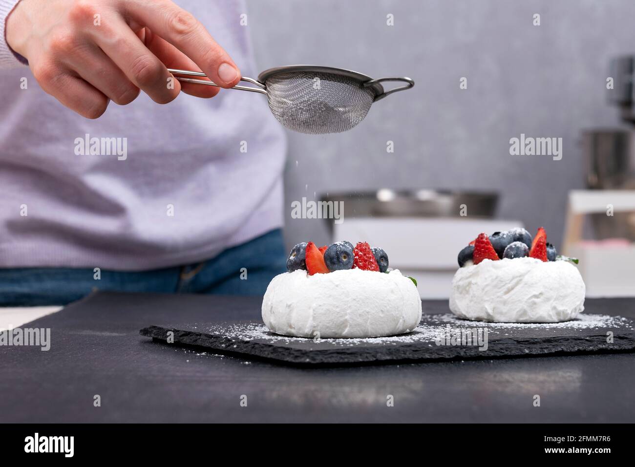 Gateaux Anna Pavlova Le Chef Patissier Saupoudrer Le Sucre Glace Sur Les Gateaux Aux Baies Photo Stock Alamy