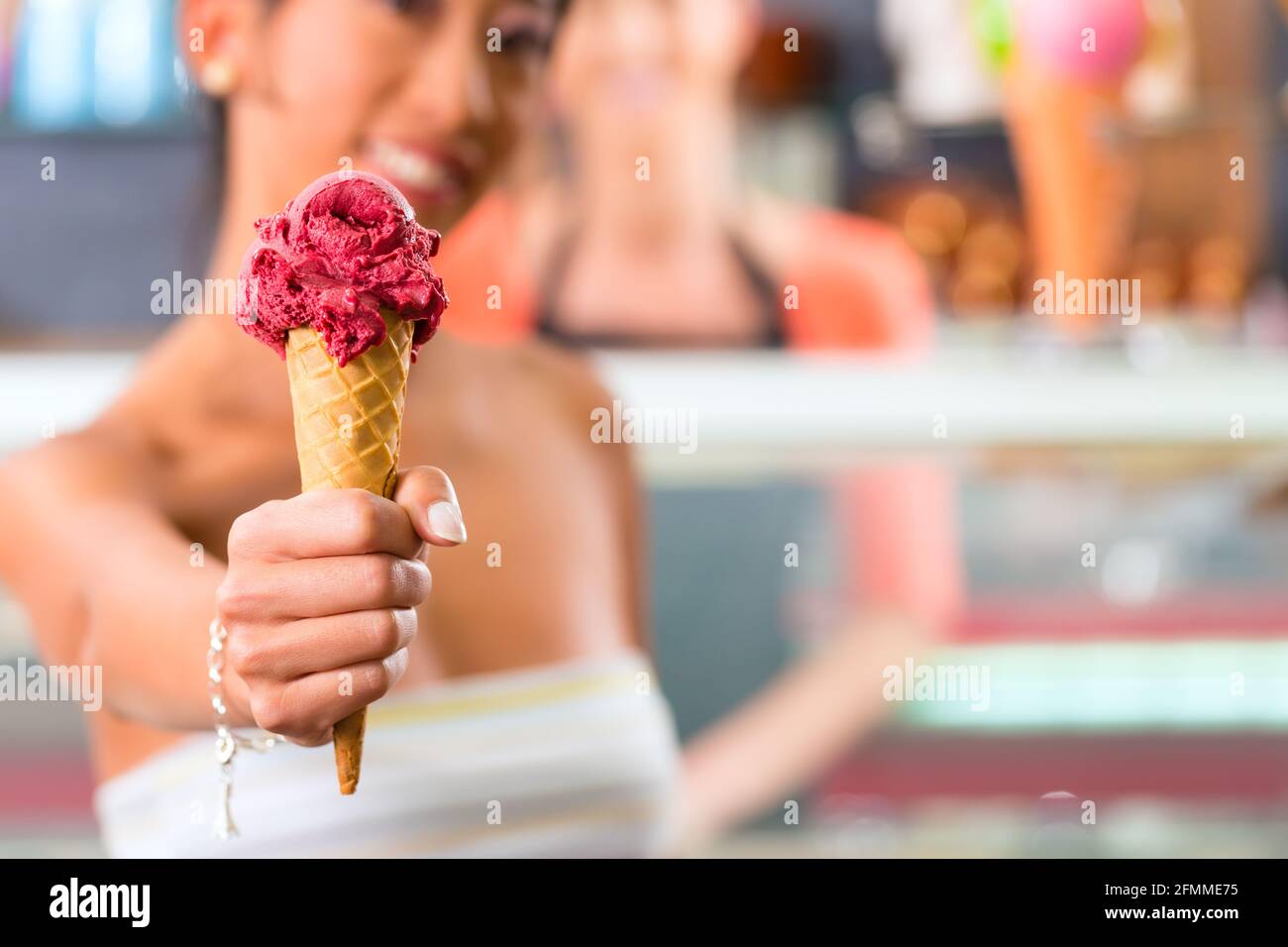 Jeune femme client dans un glacier avec cornet de crème glacée Banque D'Images