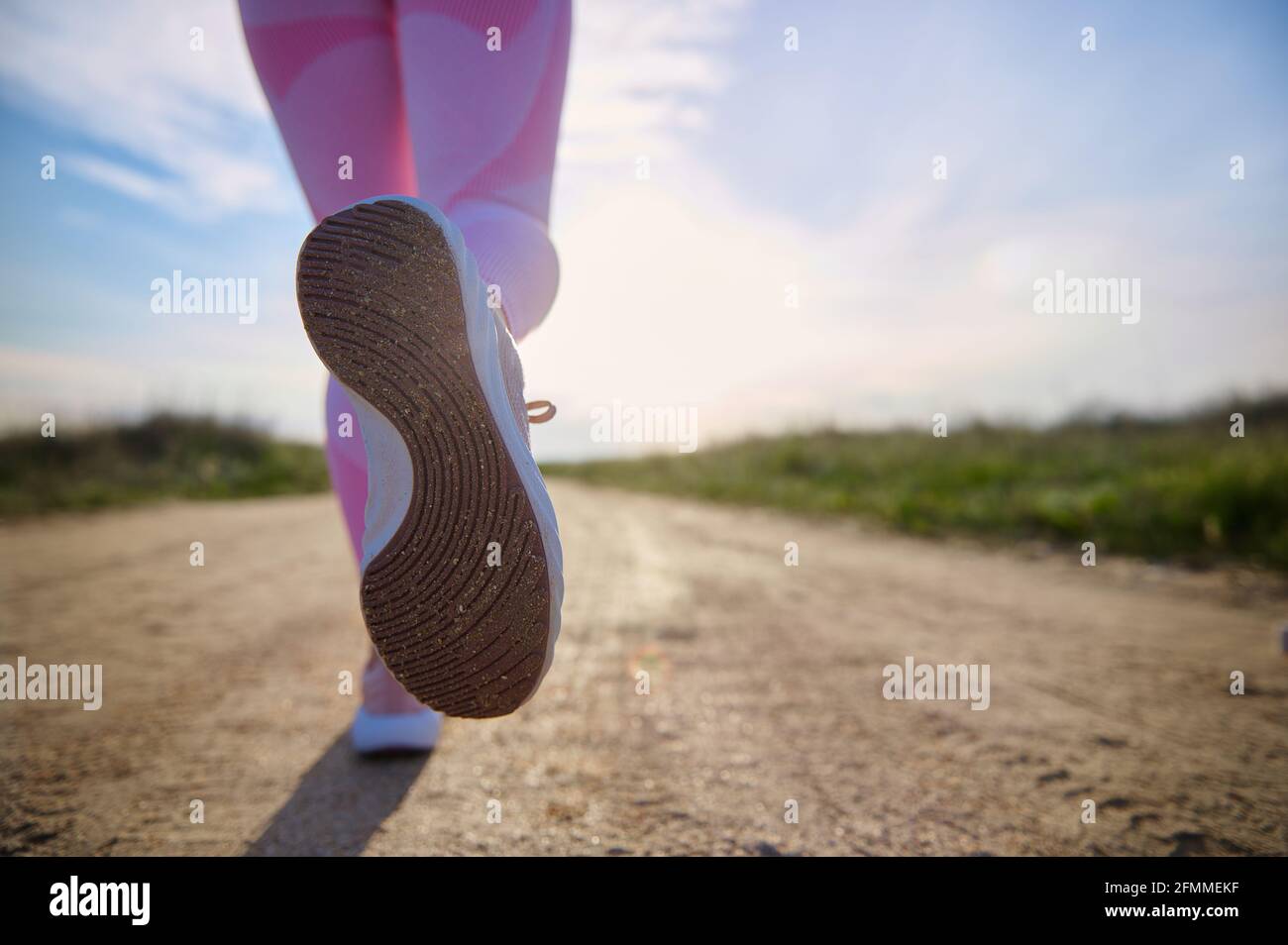 Gros plan des chaussures de sport d'une personne qui court sur la route de  steppe avec la belle lumière du soleil. Concept de cardio-training en  extérieur. Copier l'espace Photo Stock - Alamy