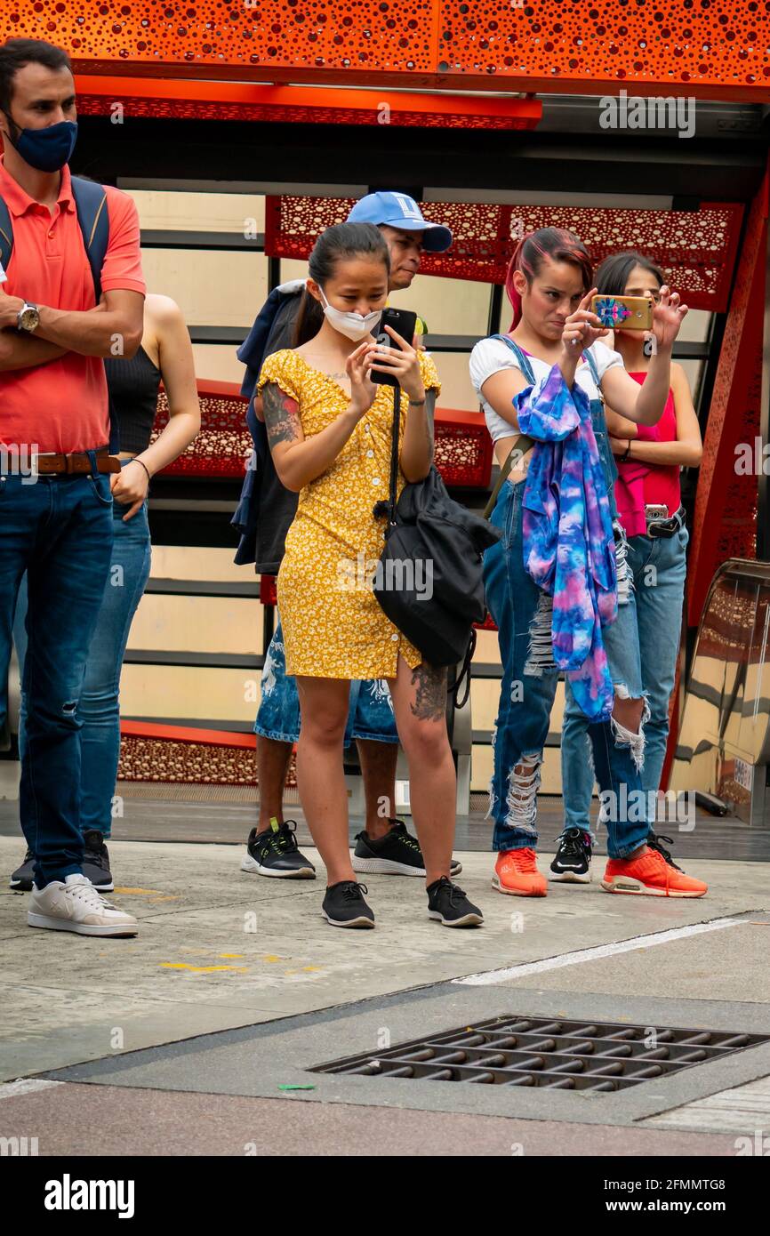 Medellin, Antioquia, Colombie - Mars 27 2021: Une jeune femme asiatique prend des photos au milieu d'un groupe de femmes latines qui regardent la danse Banque D'Images