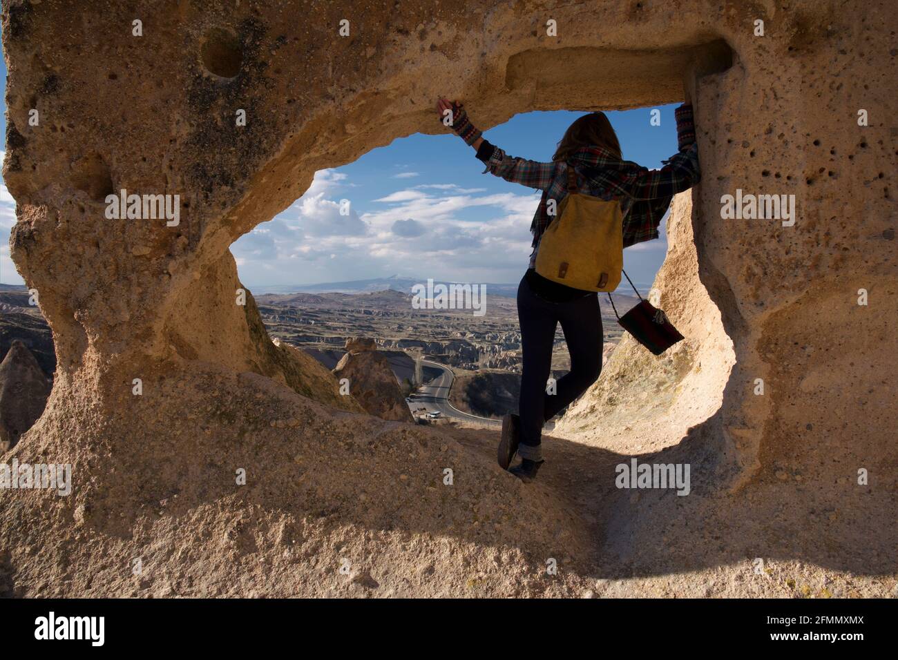 Une femelle fait une pause pour admirer la vue depuis une cheminée de fées, la Cappadoce, la Turquie Banque D'Images