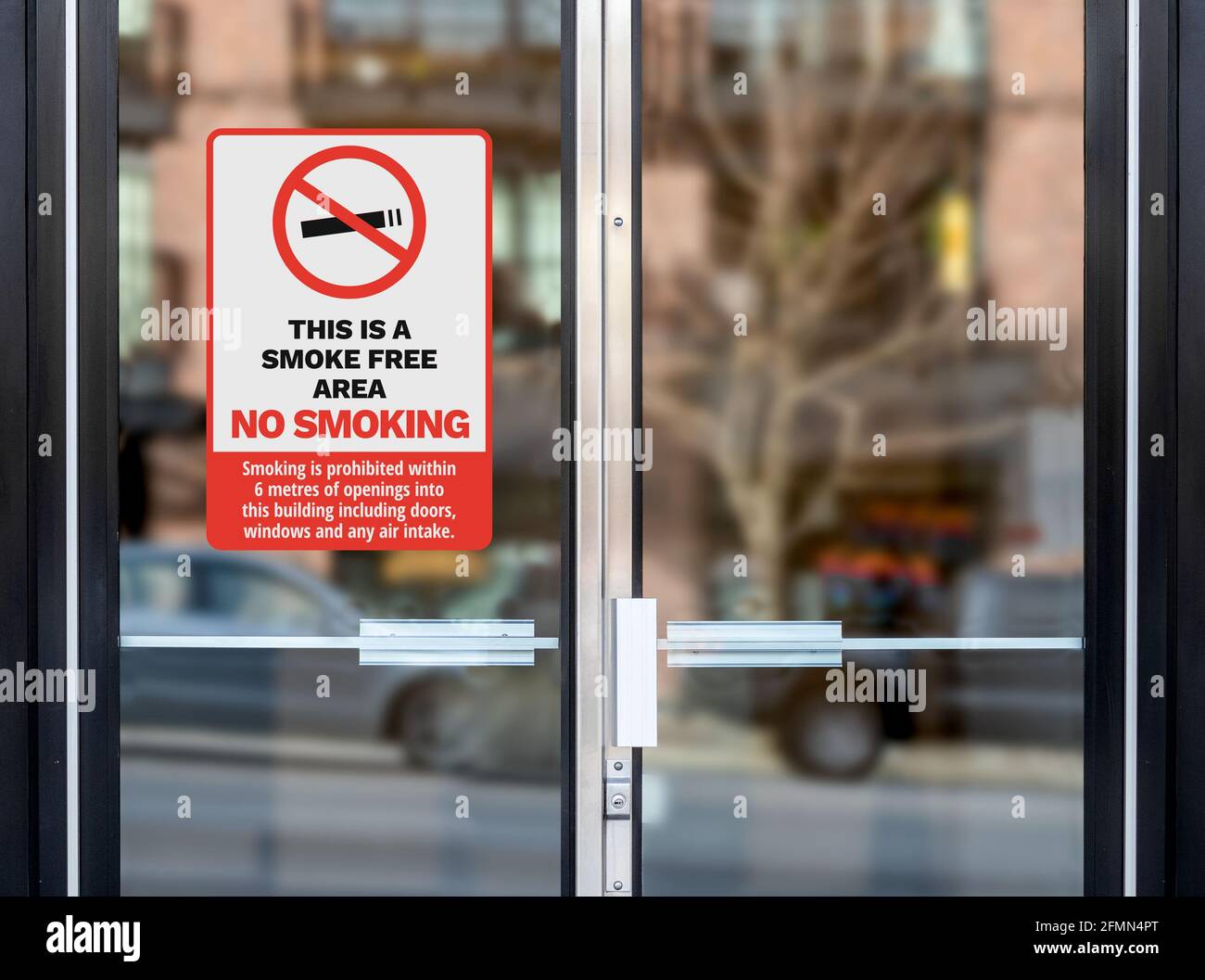 Affiche ou affiche non-fumeurs sur la porte vitrée de l'entrée du bâtiment. 'C'est un espace non-fumeurs.' Une distance fumeur de 6 mètres des portes et des fenêtres est requise Banque D'Images