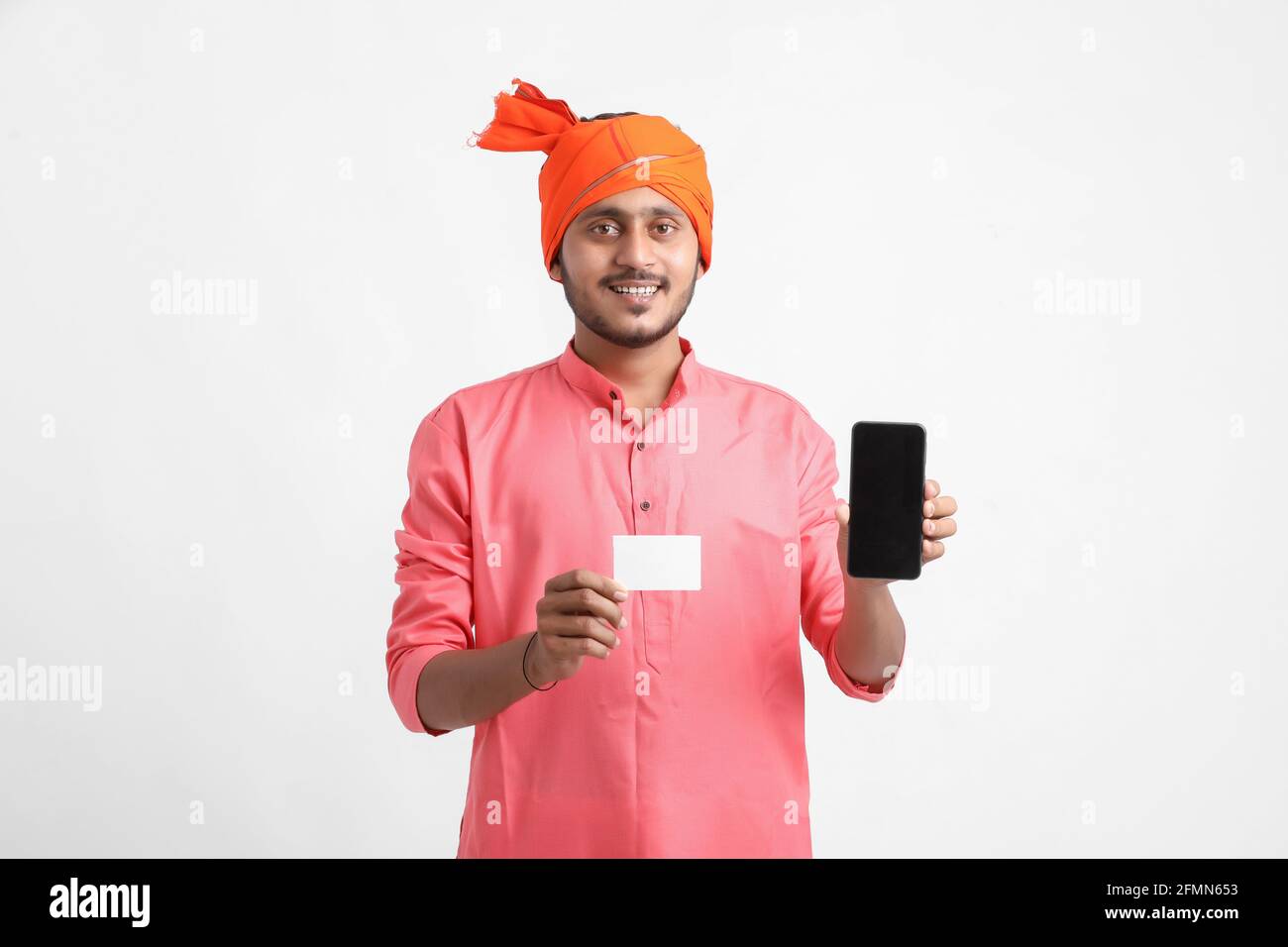 Jeune agriculteur indien montrant la carte et le smartphone sur fond blanc Banque D'Images