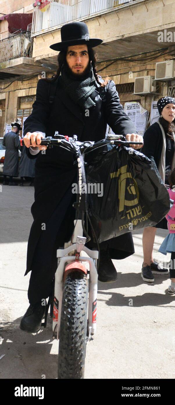 Un juif orthodoxe à vélo dans la rue Hanevi'im à Jérusalem, en Israël. Banque D'Images
