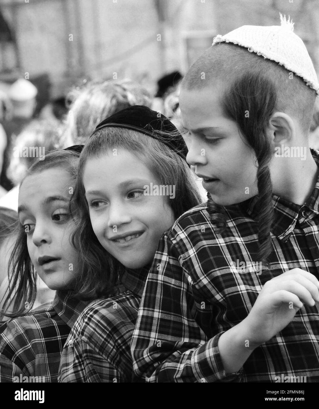 Des enfants orthodoxes juifs attendent en file pour de la nourriture et des bonbons servis par un homme juif juste pendant les préparatifs de la Pâque à MEA She'arim Jérusalem. Banque D'Images