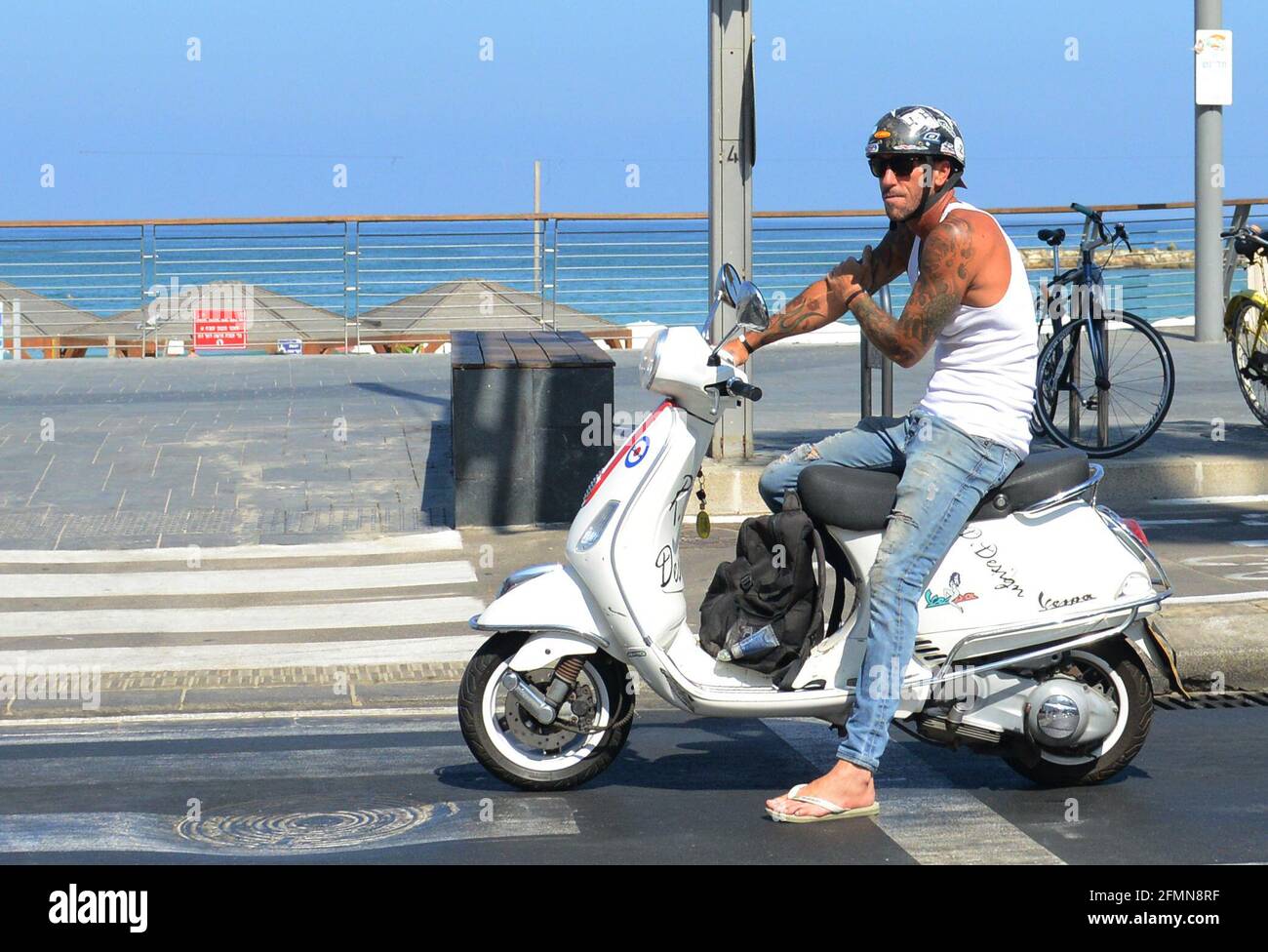 Un homme israélien sur son scooter près de la promenade du front de mer à tel-Aviv, Israël. Banque D'Images