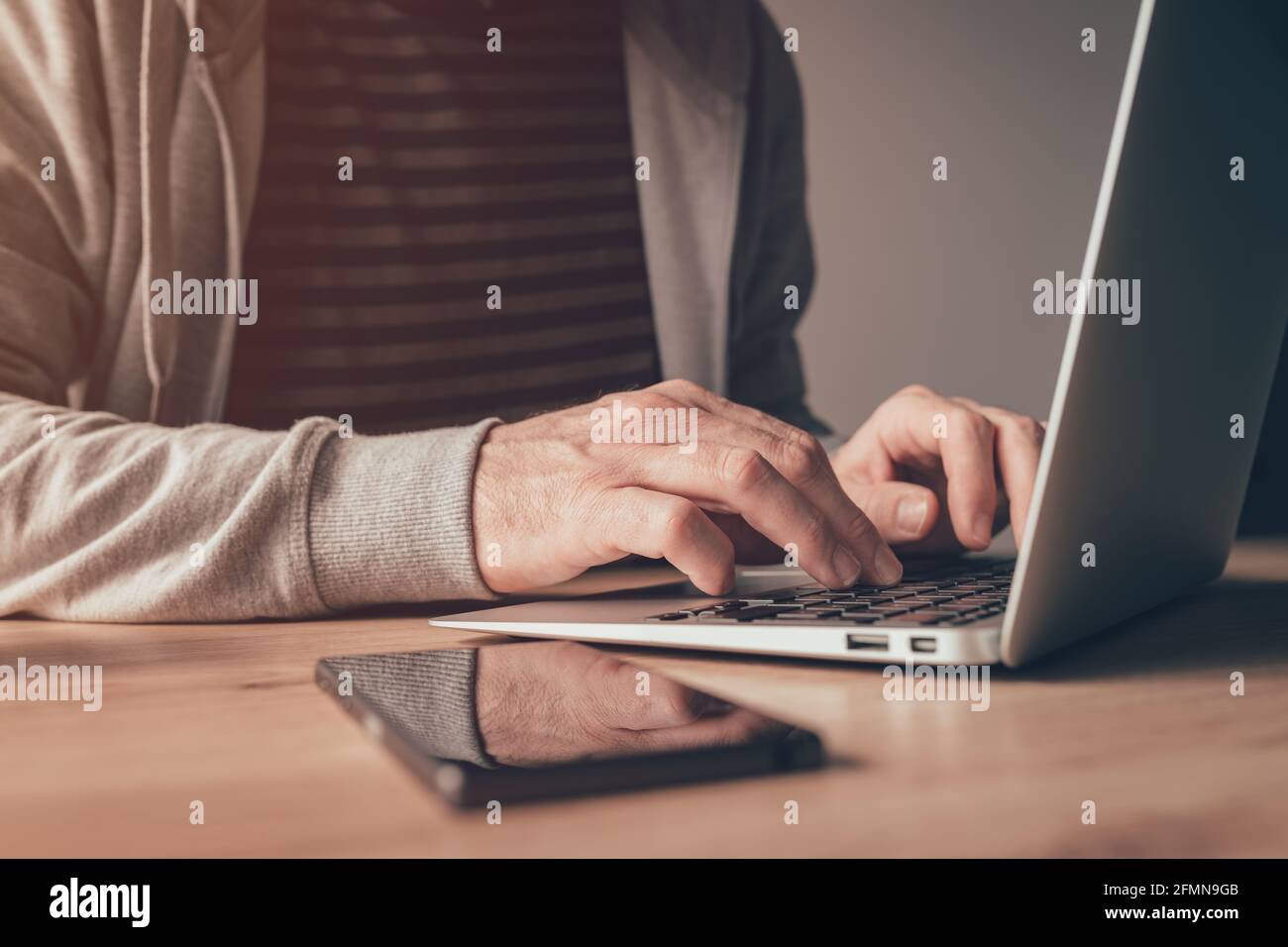 Travailleur indépendant utilisant un ordinateur portable au bureau à domicile, gros plan avec une attention sélective Banque D'Images