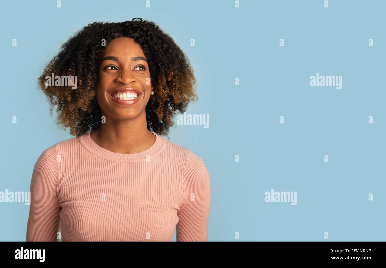 Portrait de la gaie de la femme noire avec des cheveux de boucle regardant Copier l'espace Banque D'Images