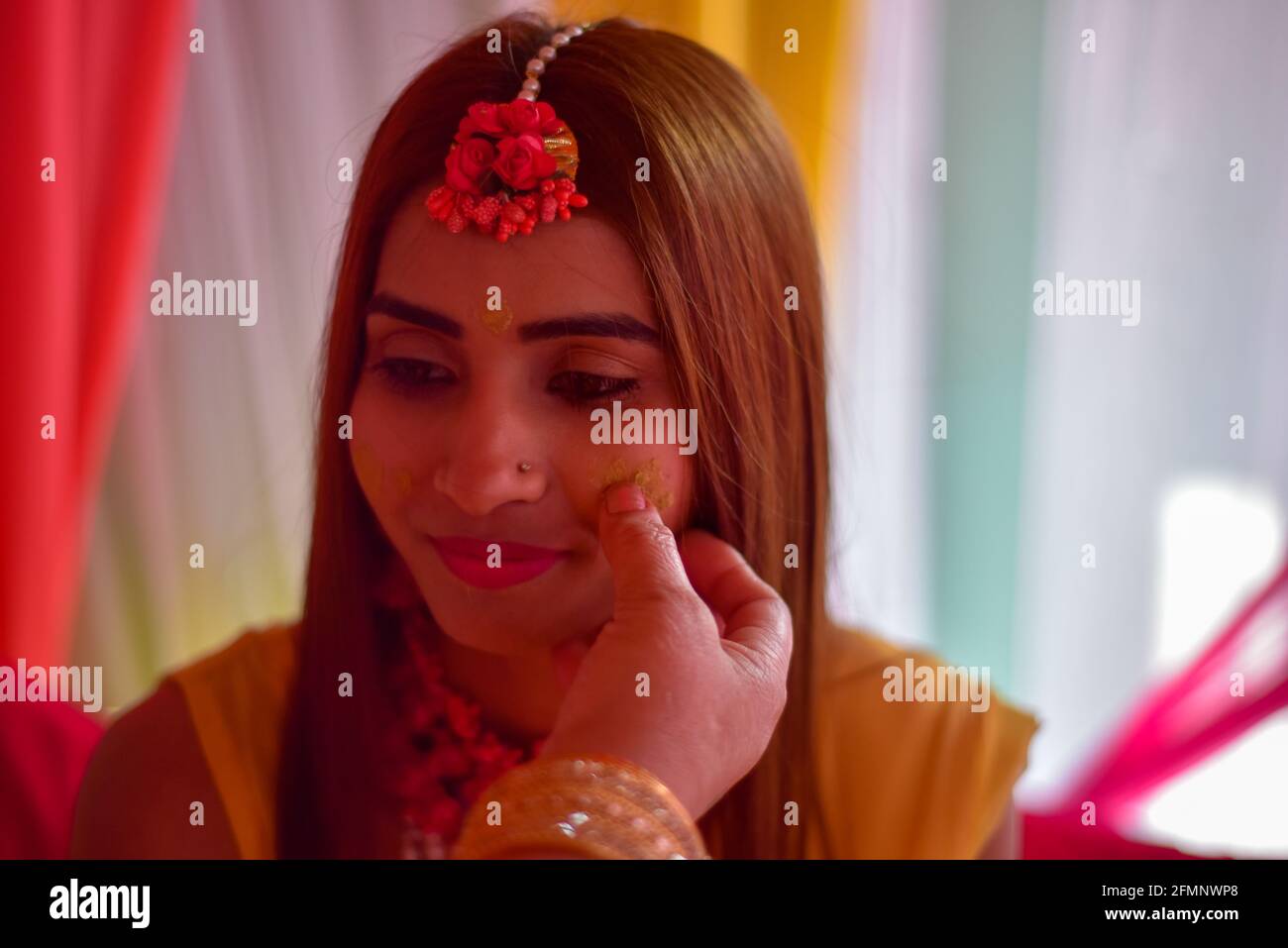 portrait de la belle mariée indienne avec de la pâte de haldi turmérique sur son visage. Banque D'Images