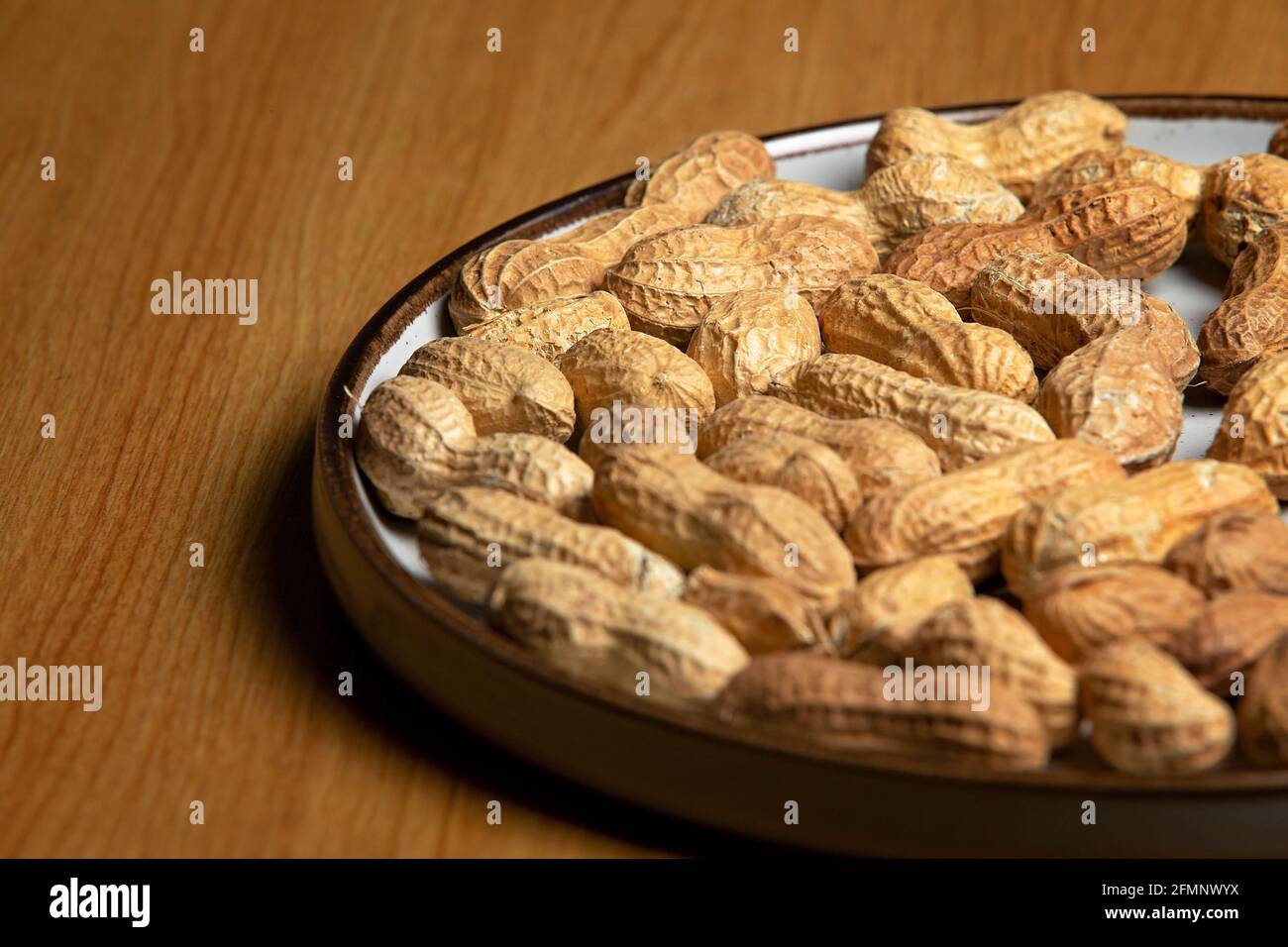 Noix de singe sur une plaque blanche sur une table en bois Banque D'Images