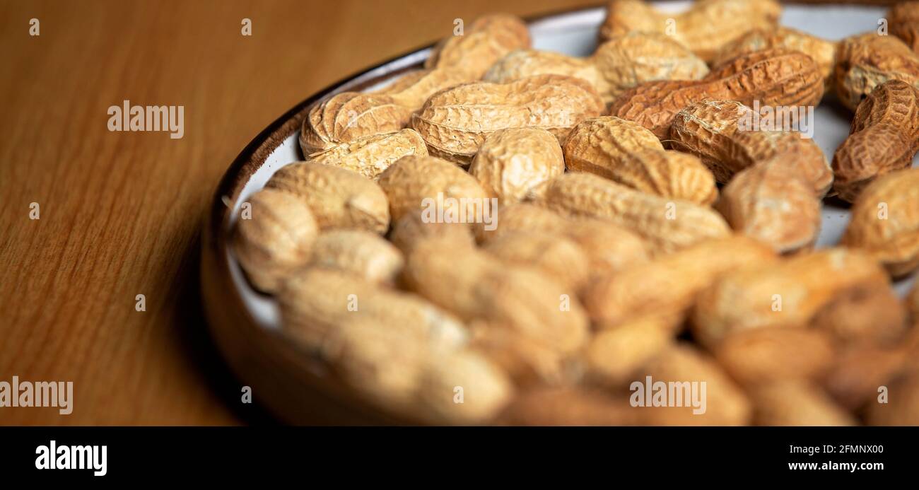 Noix de singe sur une plaque blanche sur une table en bois avec une faible profondeur de champ Banque D'Images