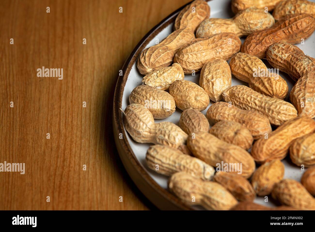 Noix de singe sur une plaque blanche sur une table en bois Banque D'Images