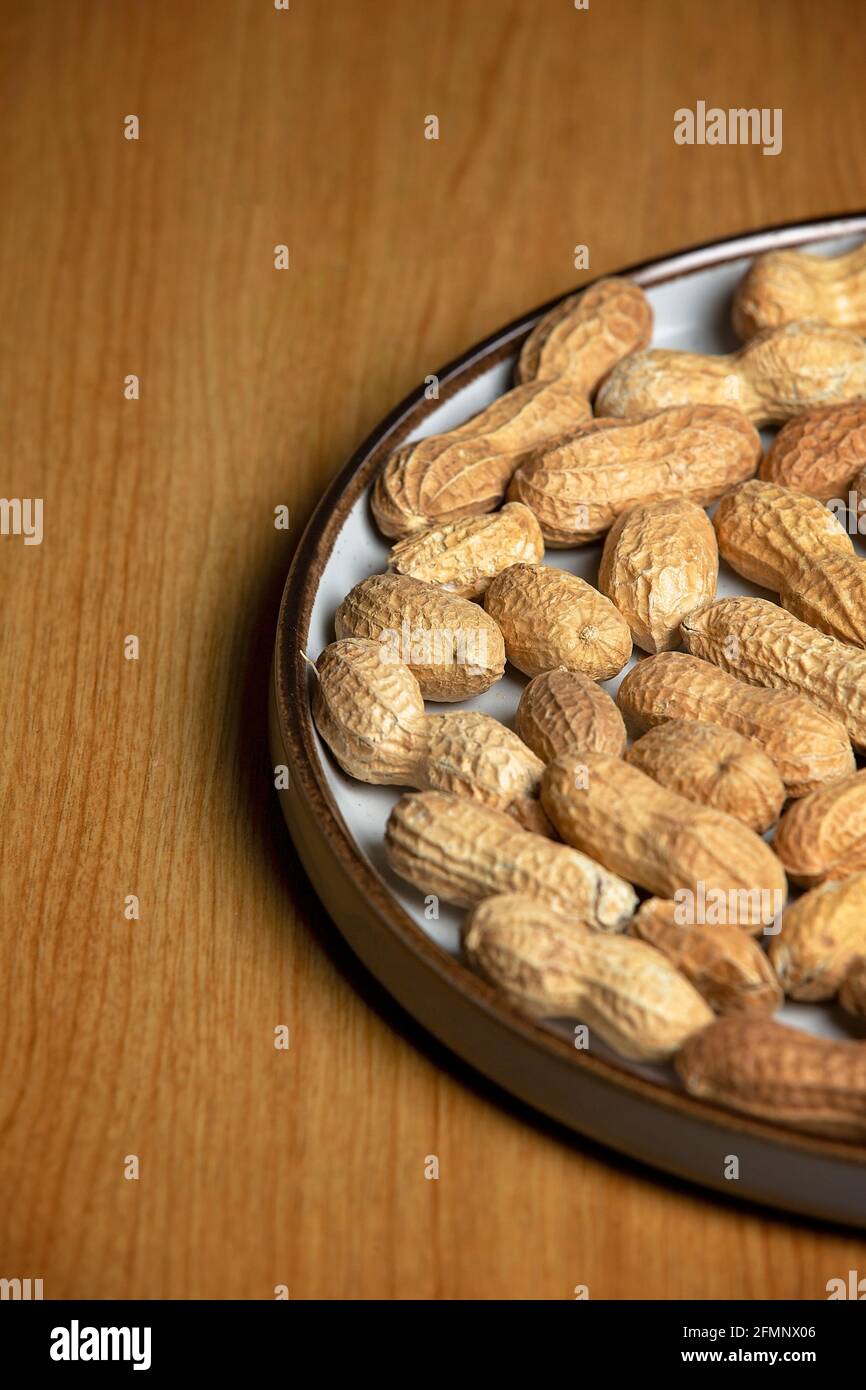 Noix de singe sur une plaque blanche sur une table en bois Banque D'Images