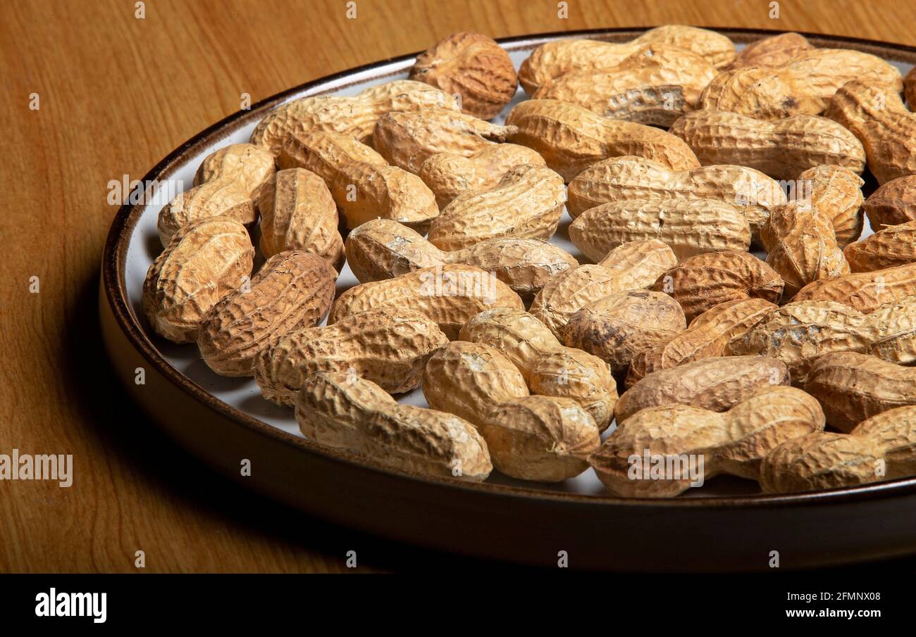 Noix de singe sur une plaque blanche sur une table en bois Banque D'Images