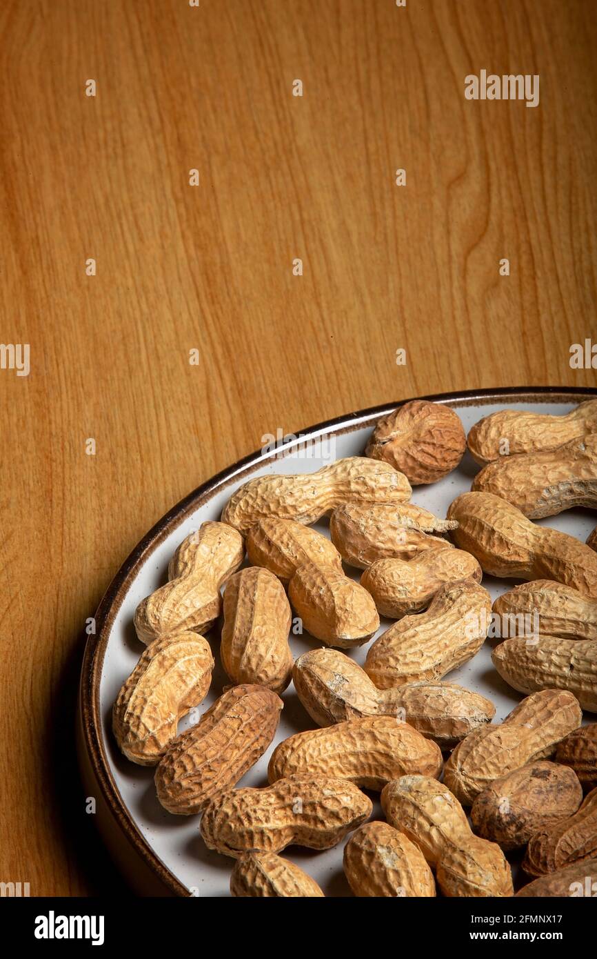 Noix de singe sur une plaque blanche sur une table en bois Banque D'Images