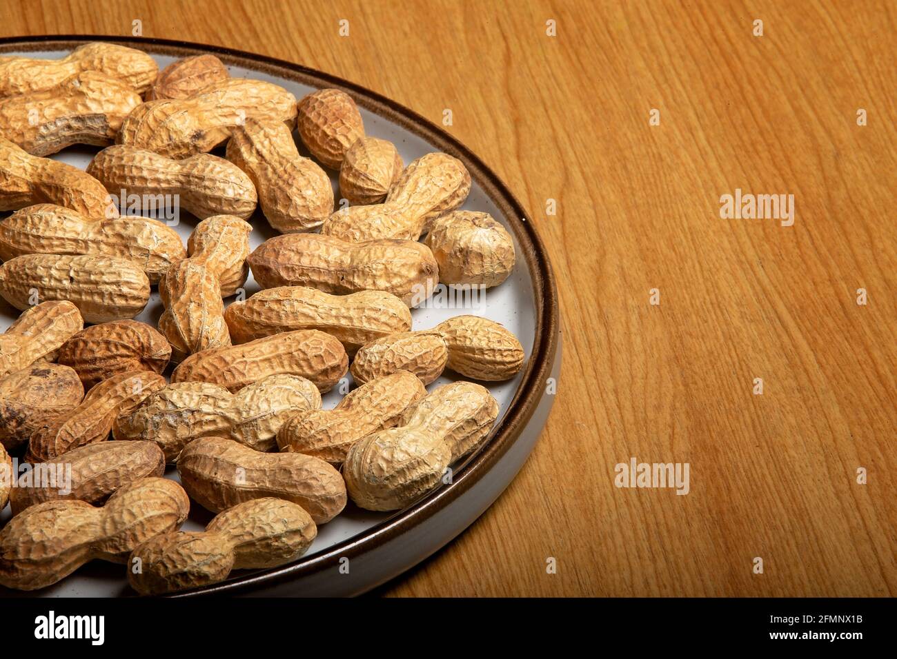 Noix de singe sur une plaque blanche sur une table en bois Banque D'Images