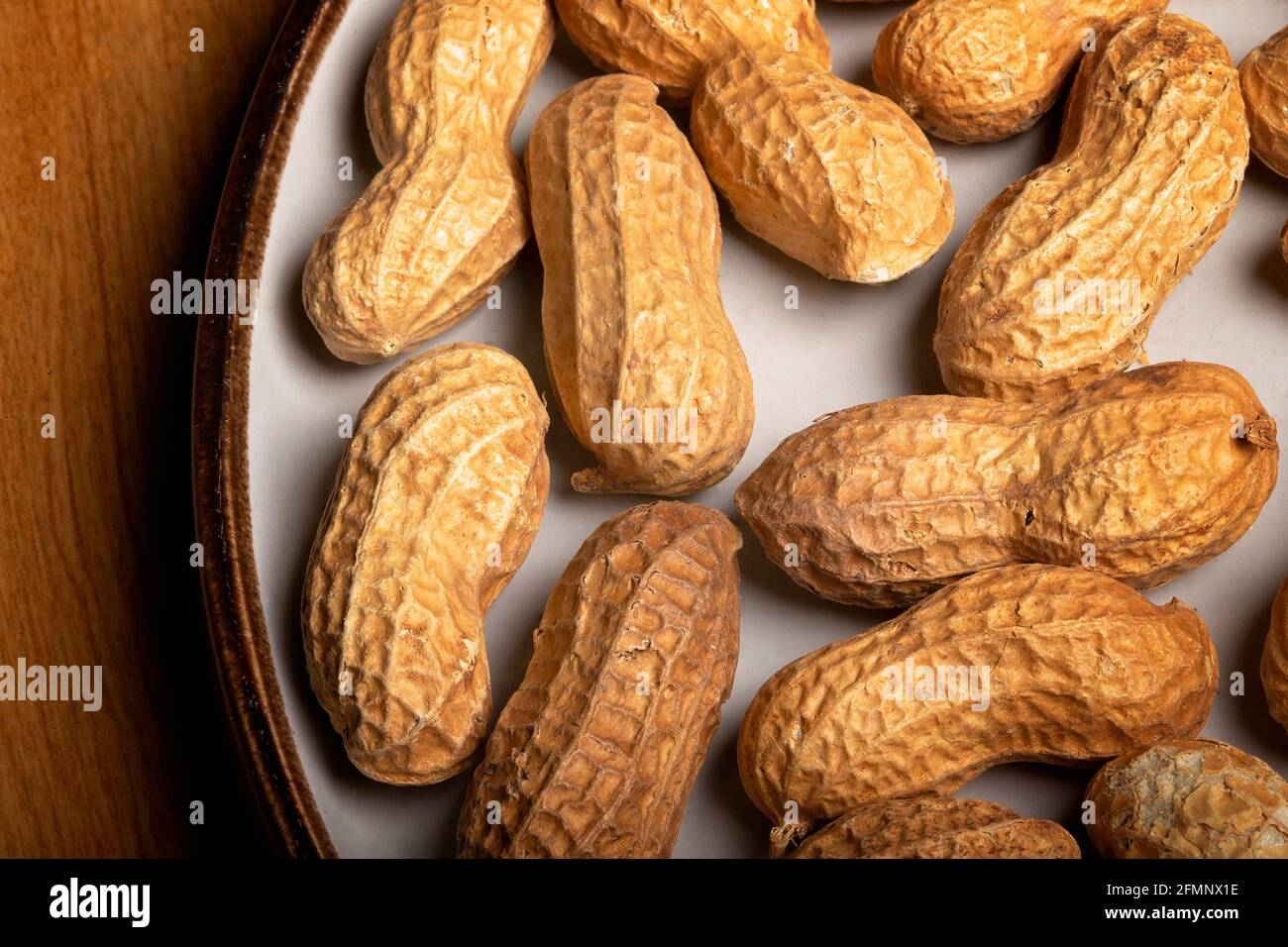 Noix de singe sur une plaque blanche sur une table en bois Banque D'Images