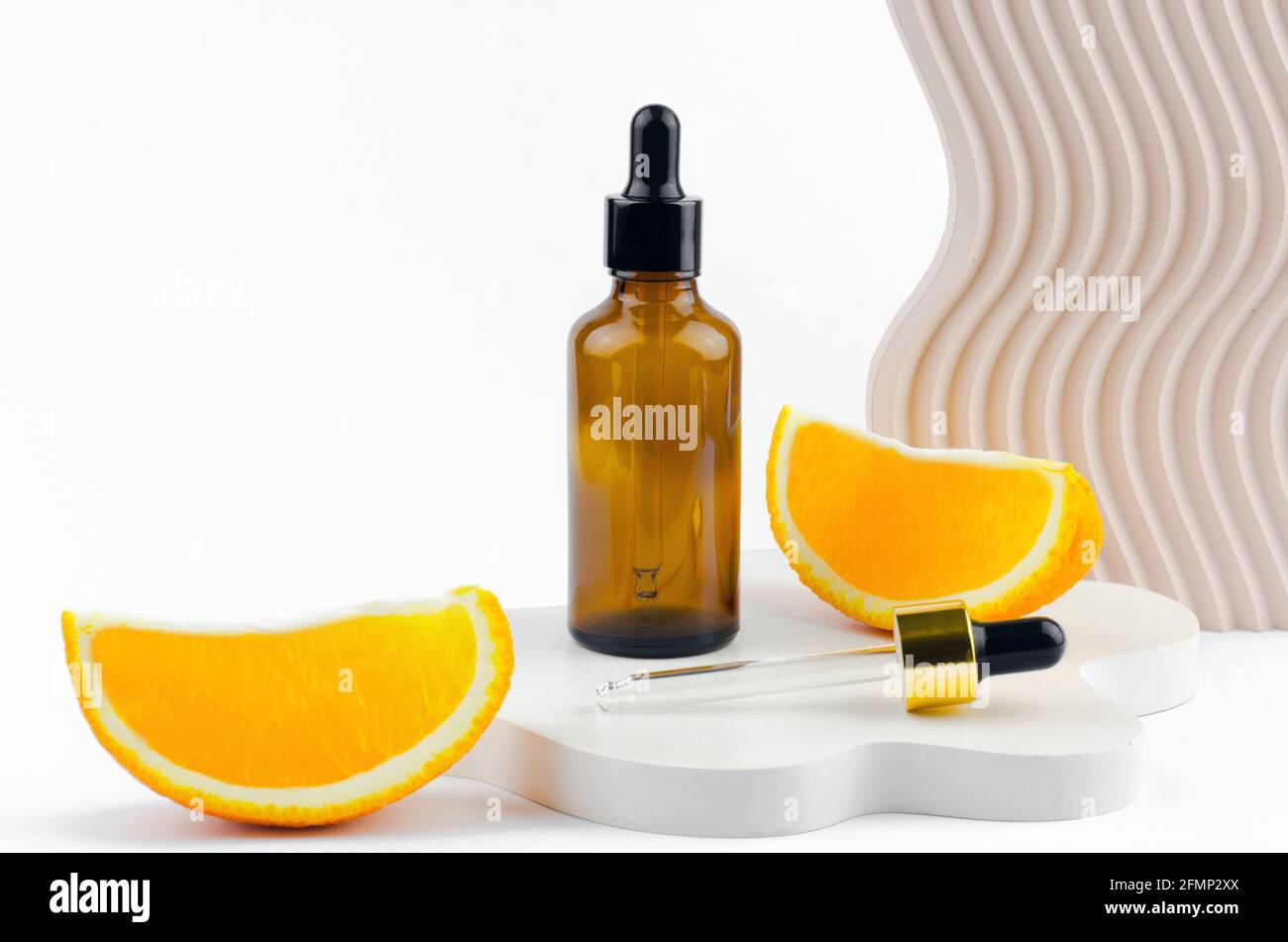 Produit cosmétique aromatique pour les soins de la peau et des cheveux. Sérum dans un flacon en verre avec une pipette. Emballage d'un produit cosmétique. Huiles à l'extrait d'orange Banque D'Images