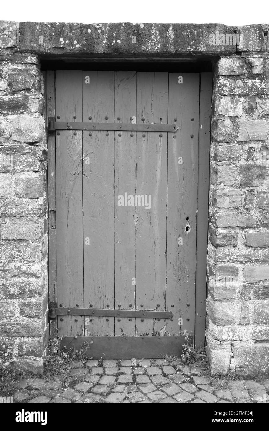 photo en noir et blanc d'une porte médiévale en bois comme accès à un vieux château médiéval Banque D'Images