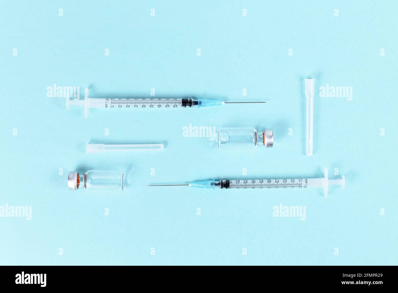 Flacons de vaccins avec seringues sur fond bleu Banque D'Images