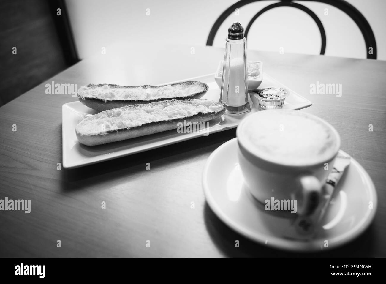 Gros plan en niveaux de gris d'une tasse de café et de pain coupes Banque D'Images