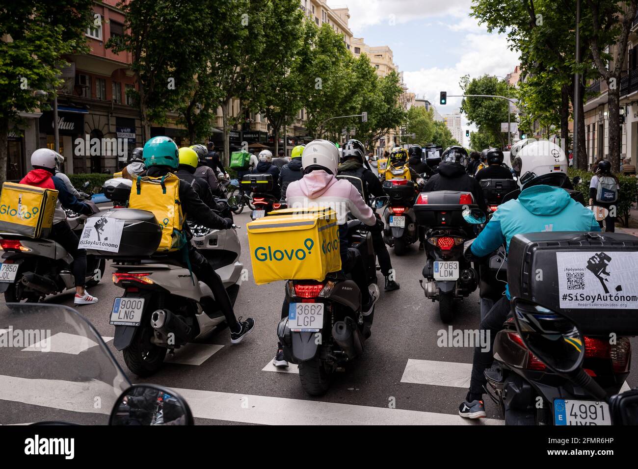 Des groupes de cavaliers sur des motos et des vélos devant Puerta de Moncloa pendant la démonstration.des dizaines de 'riders' (distributeurs de nourriture) détestent, revendiquant leur travail en tant que indépendant et contre les conditions des compagnies de livraison telles que Globo et Deliveroo. Ce matin, l'Espagne a approuvé la « loi Riders » et a donné aux entreprises une période de 3 mois pour embaucher des personnes au lieu de les avoir comme de faux pigistes. Le ministre du travail et de l'économie sociale, Yolanda Díaz, a souligné que l'Espagne sera le premier pays à avoir une norme sur les plates-formes numériques. Banque D'Images