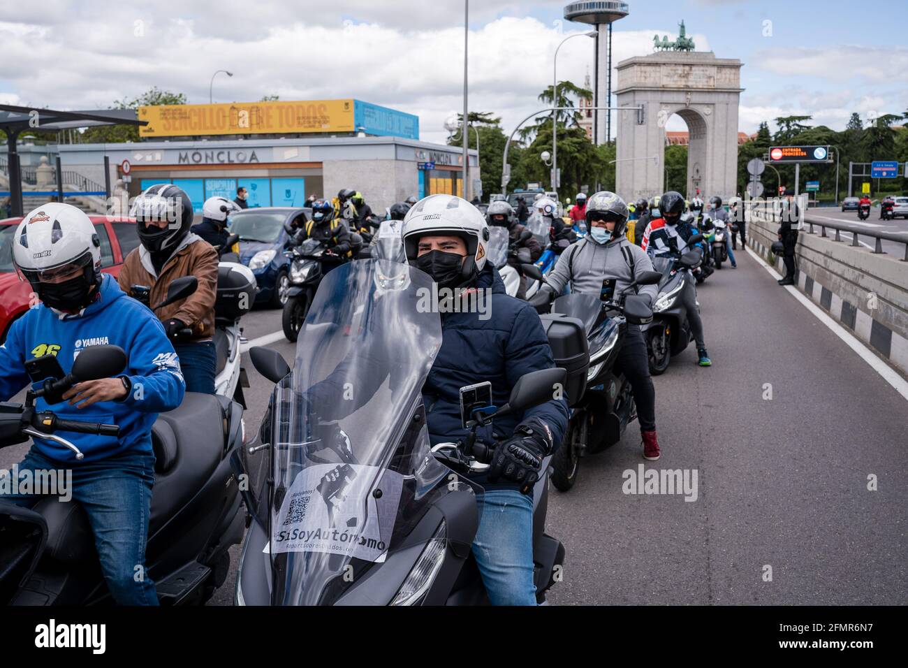 Des motards en moto devant la Puerta de Moncloa, pendant la démonstration.des dizaines de "motards" (distributeurs de produits alimentaires) détestent, revendiquant leur travail en tant que freelance et contre les conditions des compagnies de livraison telles que Globo et Deliveroo. Ce matin, l'Espagne a approuvé la « loi Riders » et a donné aux entreprises une période de 3 mois pour embaucher des personnes au lieu de les avoir comme de faux pigistes. Le ministre du travail et de l'économie sociale, Yolanda Díaz, a souligné que l'Espagne sera le premier pays à avoir une norme sur les plates-formes numériques. Banque D'Images