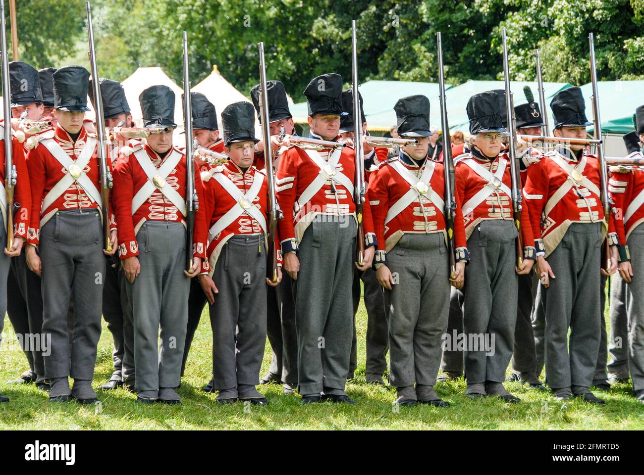 Redcoats à l'état d'attente : infanterie britannique dans le camp des alliés faisant l'exercice du tir de volley pendant la reconstitution de la bataille de Waterloo. Banque D'Images