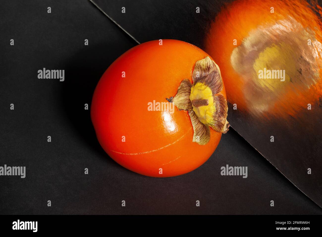 persimmon miroir sur fond noir Banque D'Images