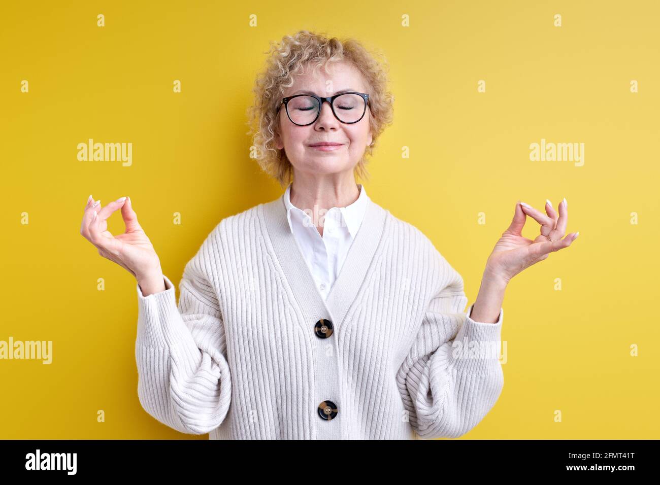 Femme âgée en lunettes de vue garder calme, namaste, isolé sur fond jaune,  engagé dans la méditation de yoga, soulager la tension. Portrait de fem  ridé Photo Stock - Alamy