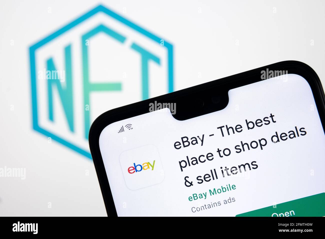 CONCEPT NFT EBAY. Application eBay vue sur le smartphone et logo de jeton non fongible flou sur l'écran d'arrière-plan flou de l'ordinateur portable. Stafford, Royaume-Uni Banque D'Images