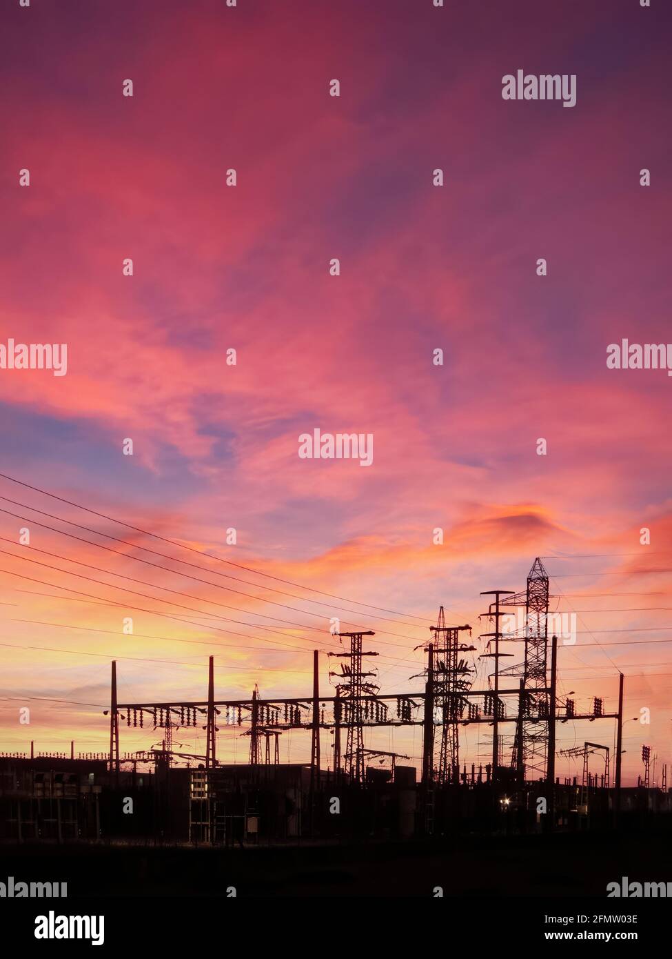 Sous-station de transformateur de puissance, sous-station de transformateur d'électricité, centre de transformation électrique, silhouette contre un ciel au coucher du soleil , verticale Banque D'Images