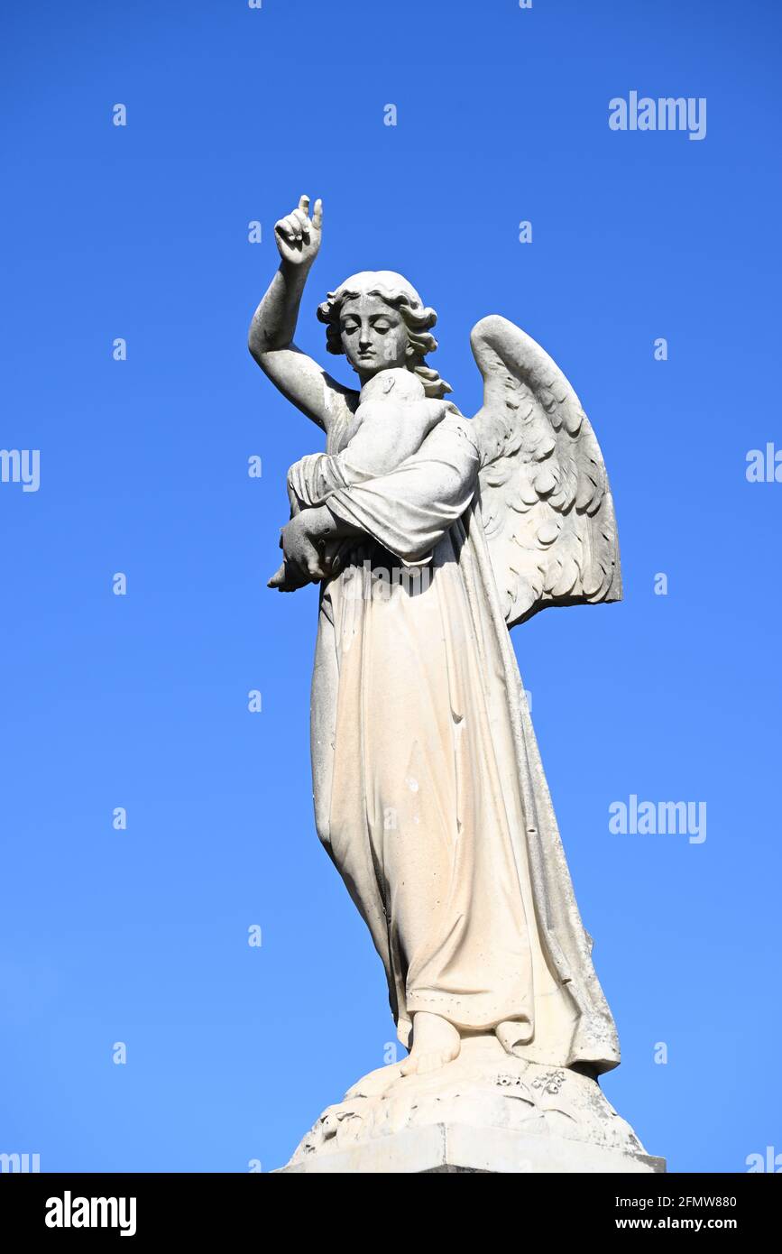 Une Sculpture Endommagee D Un Ange Tenant Un Bebe Avec Un Ciel Bleu Clair En Arriere Plan Photo Stock Alamy