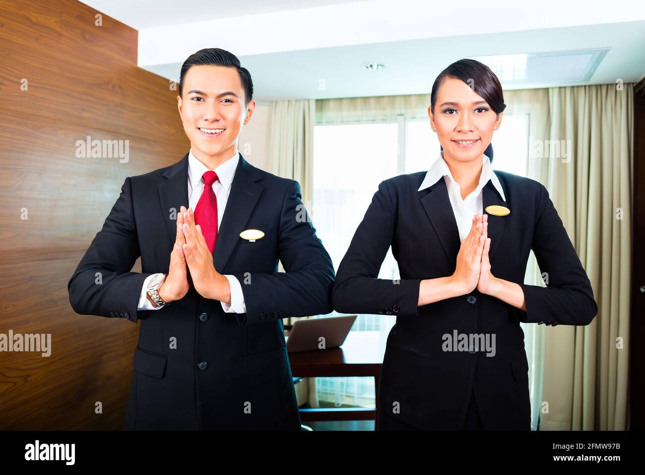 Portrait du personnel de l'hôtel avec les mains de souhaits mis ensemble Banque D'Images