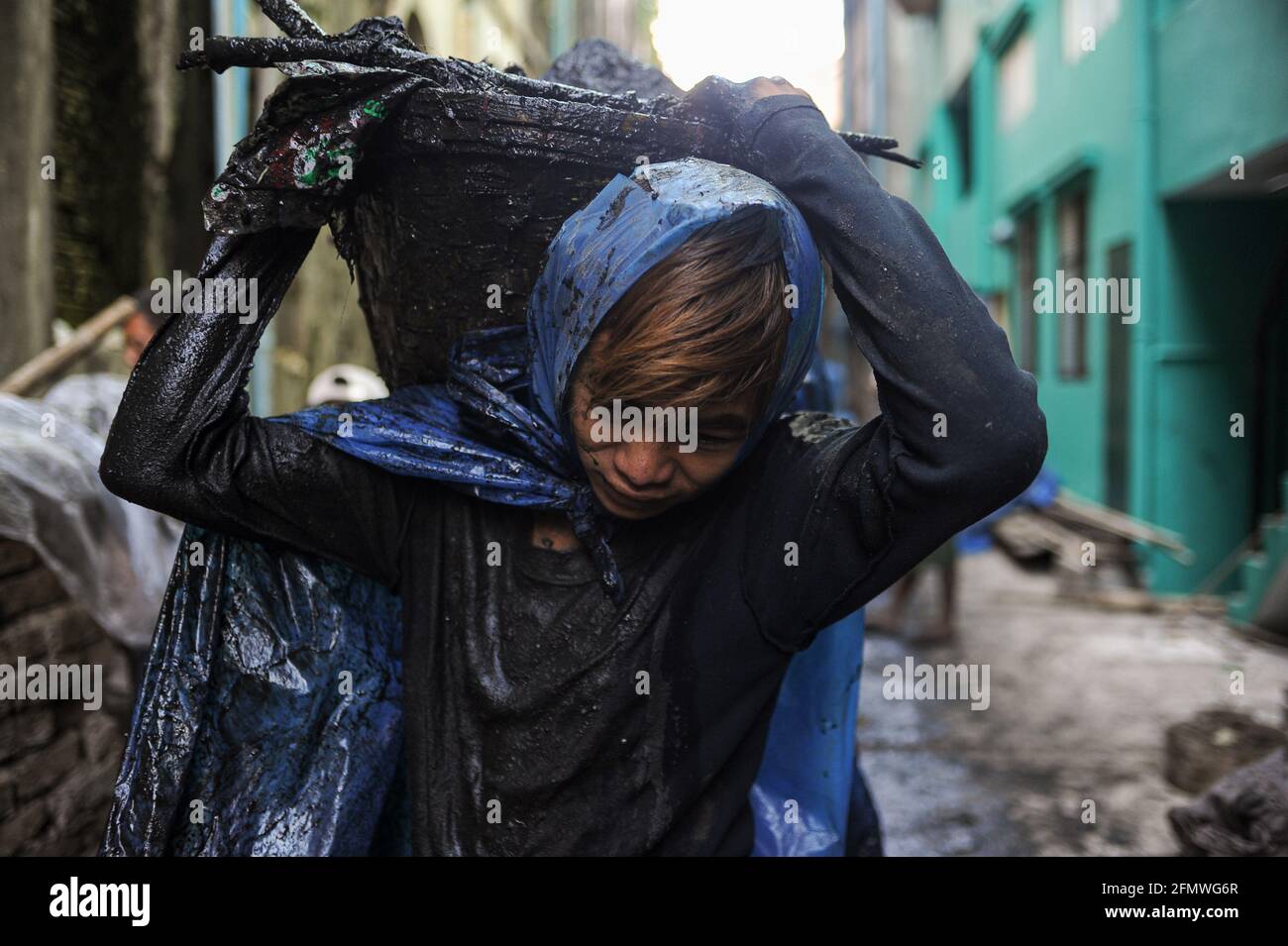 19.02.2014, Yangon, Myanmar, Asie - UN jeune épurateur d'égouts portant des vêtements de protection simples faits de sacs en plastique déchirés nettoie les égouts de la ville. Banque D'Images