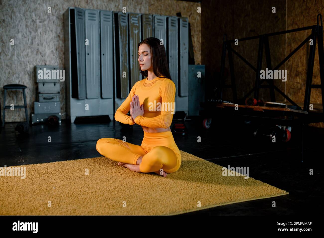 belle fille dans un sportswear jaune fait dans le yoga, la respiration correctement. Salle de sport moderne Banque D'Images