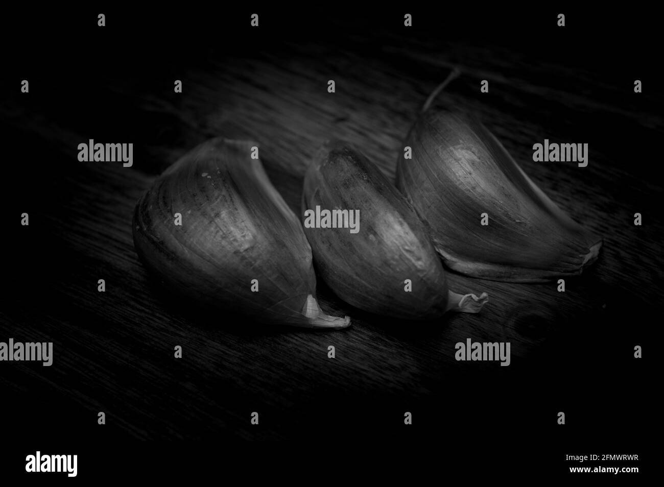Ail présenté en noir et blanc sur fond de bois Banque D'Images