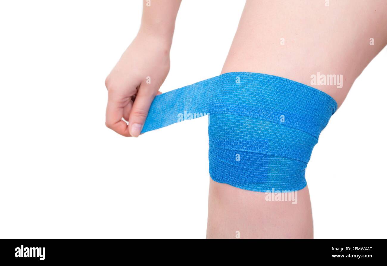 Bandage élastique bleu sur l'articulation du genou pour fixer la plaie à  genoux, fond blanc, isoler Photo Stock - Alamy