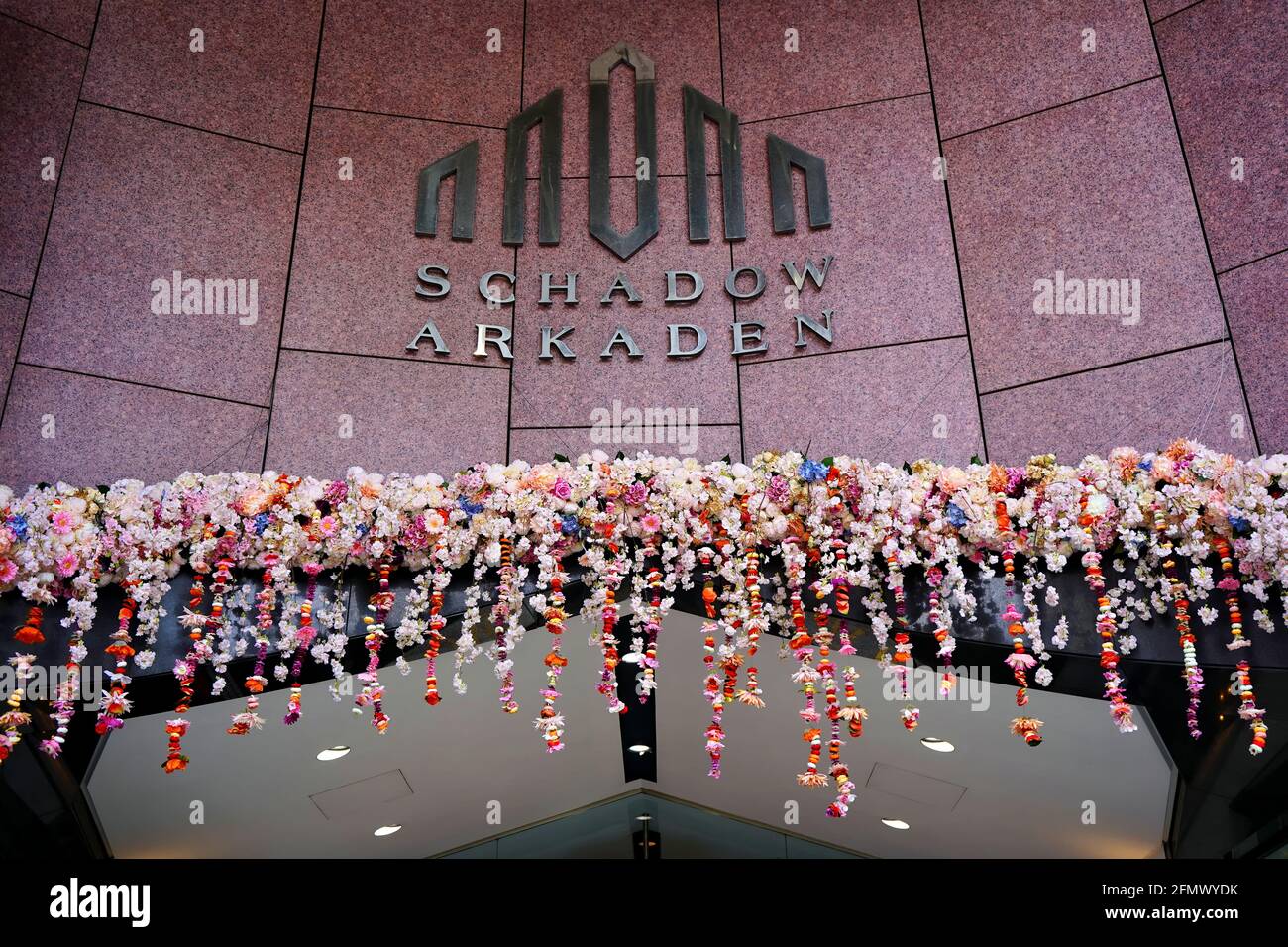Logo d'entrée du centre commercial 'Schadow-Arkaden' avec décoration colorée de fleurs printanières. Emplacement : centre-ville de Düsseldorf. Banque D'Images