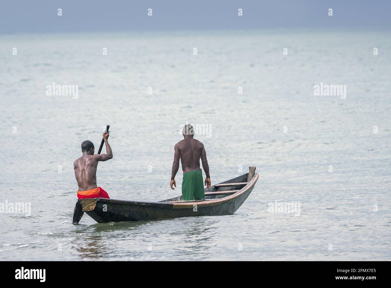 Deux pêcheurs africains noirs sur un canot de Dugout en bois Banque D'Images